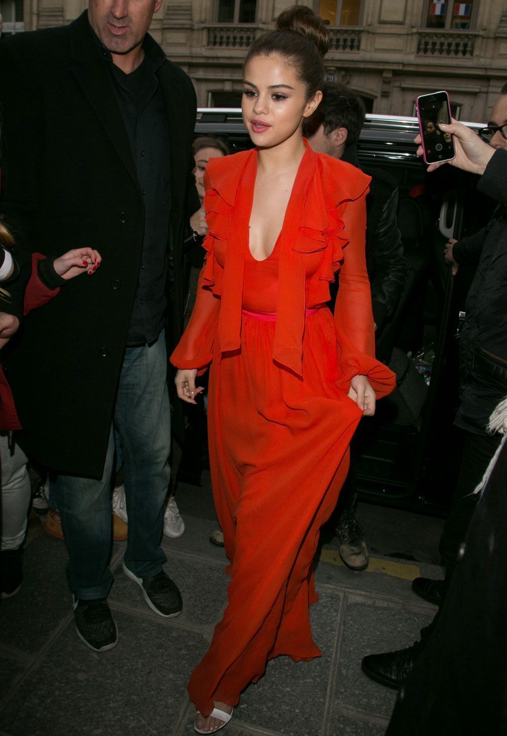 Selena Gomez, ispititoare intr-o rochie oranj, decoltata. Artista a facut furori pe strazile din Paris