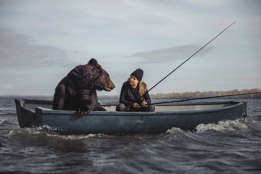 O femeie pescuiește din barcă alături de un urs. Momentul a devenit viral