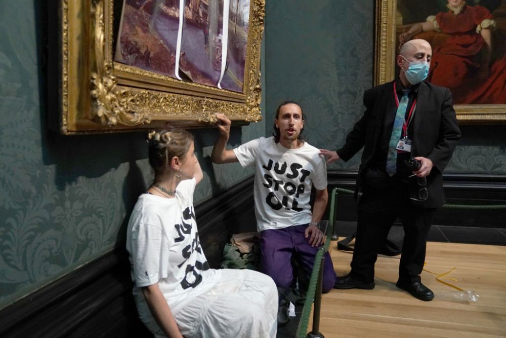 Protest lipicios la muzeu. Doi tineri s-au lipit cu adeziv de un tablou și i-au sfidat pe agenții de pază
